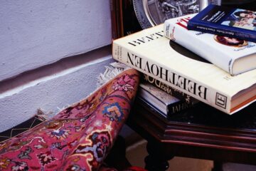 Books on a table beside a rug